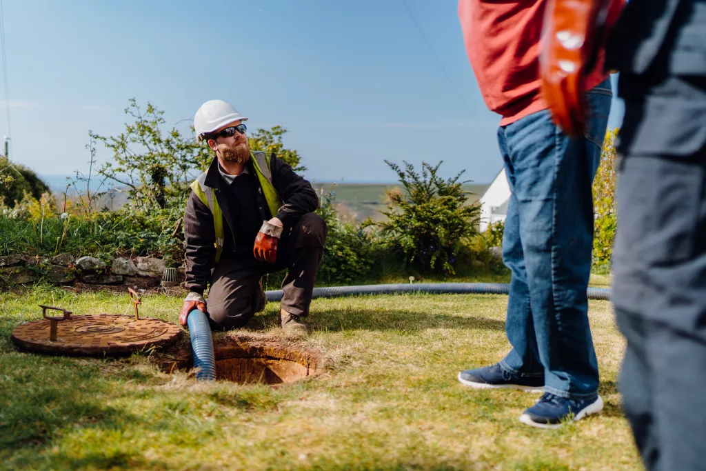 West Wales Waste engineer emptying a septic tank while speaking with a customer